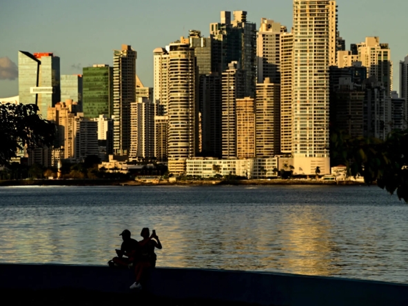 A city with red rooftops in the foreground and skyscrapers in the background